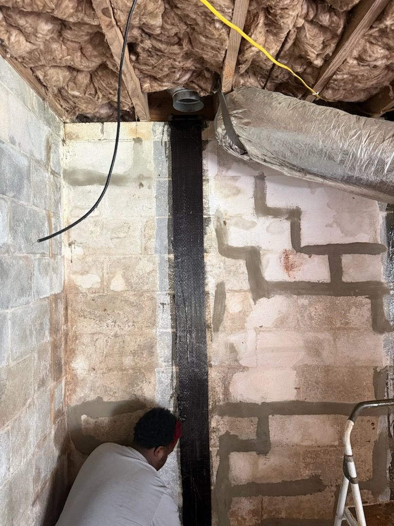 Carbon fiber strap being installed on a block basement wall