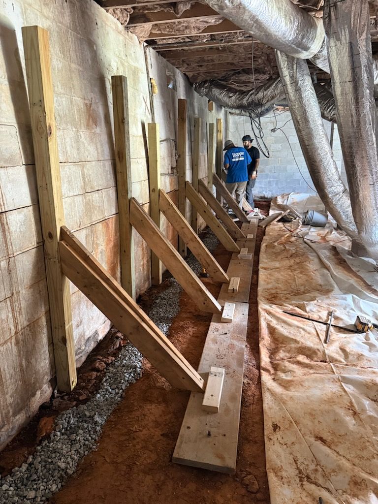 Foundation Worx crew installing temporary bracing along a block basement wall