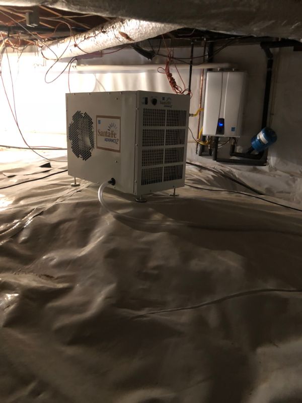 Crawl space dehumidifier sitting on an encapsulated crawl space floor