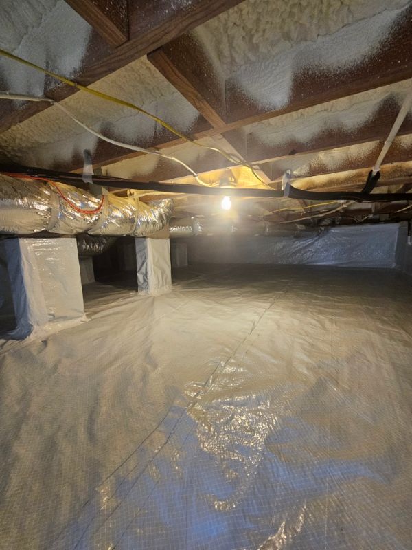 Encapsulated crawl space with white liner covering the floor and wrapped piers