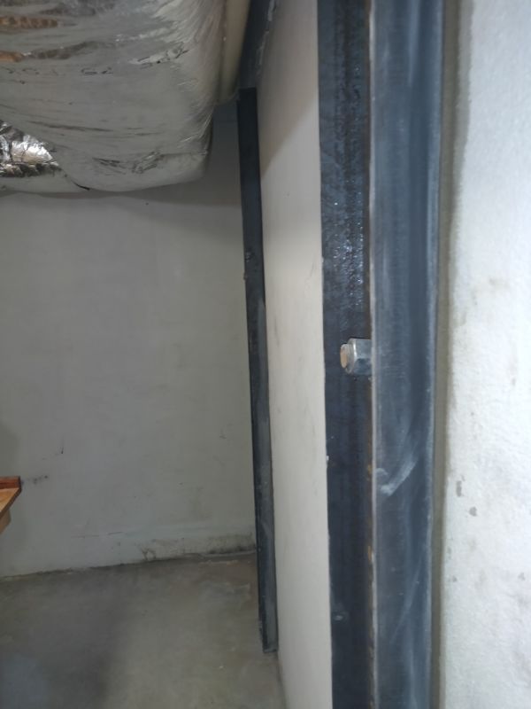 Close view of a bolted steel wall beam against a basement wall
